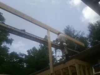 Carpenter setting a ridge beam over a new addition frame — Ice Dam Removal by Roofing Brothers in Jellico