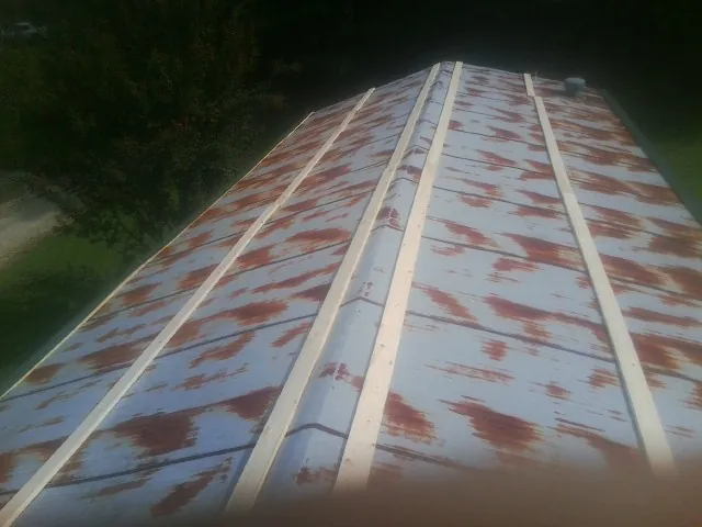 Rusted metal roof panels with new wood purlins before replacement — Storm Damage Roof Repair in Jellico by Roofing Brothers