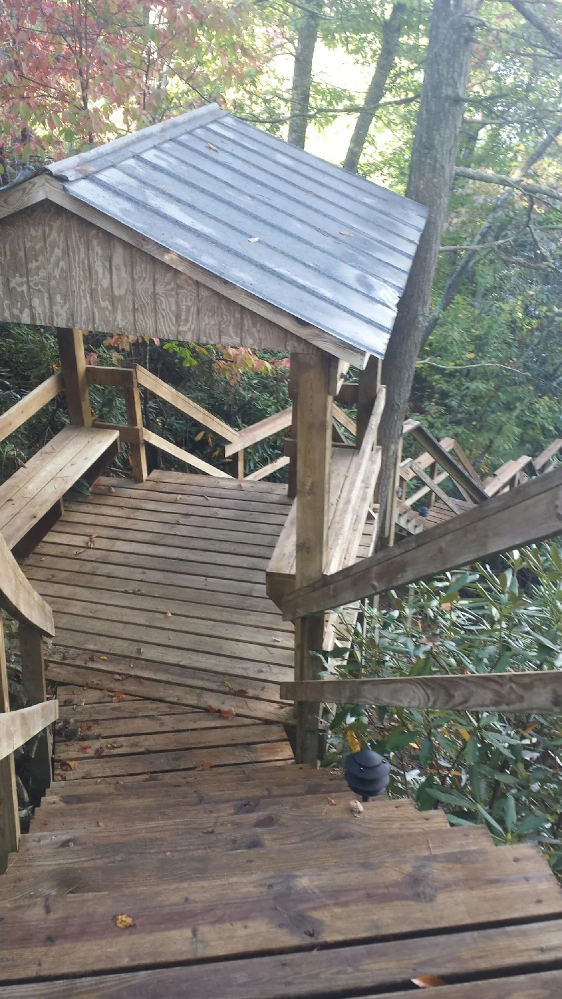 Metal roofed shelter over wooden steps on a wooded walkway — Skylight Repair & Installation work by our crew in Jellico