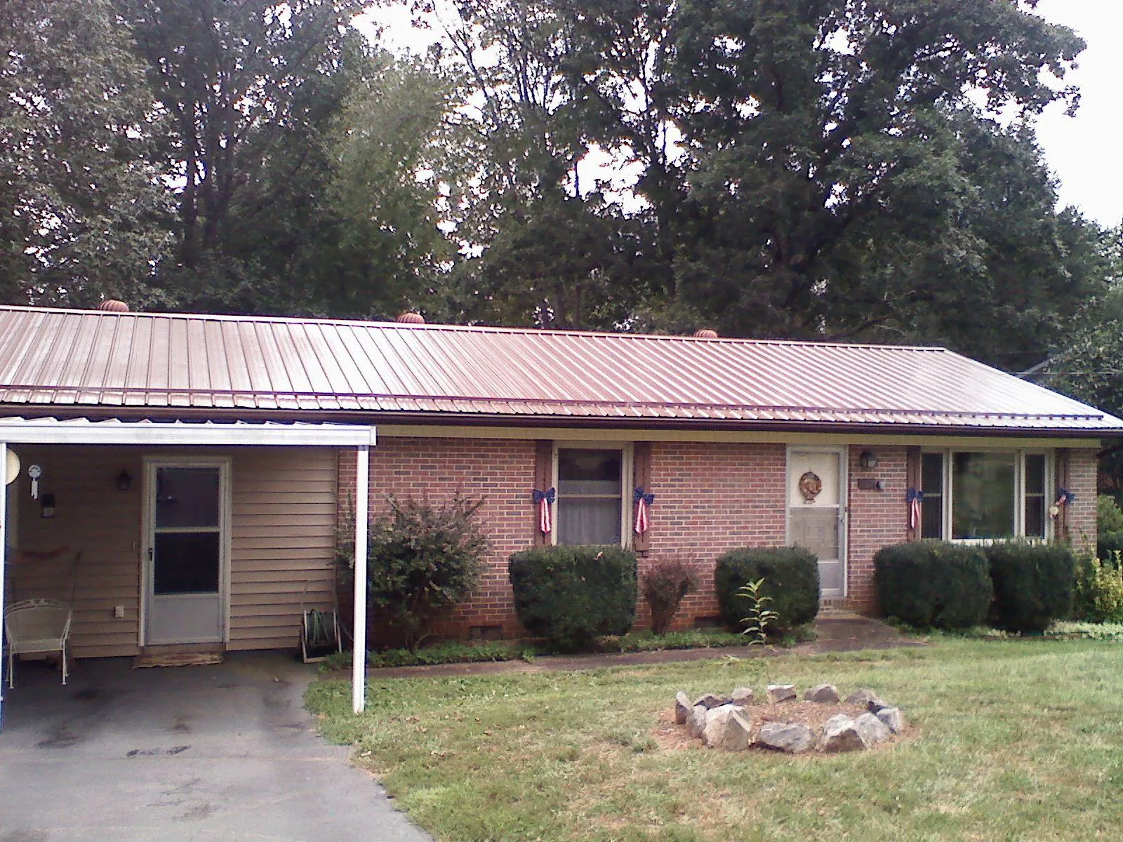 Bronze metal roof and carport on a brick ranch home — Roof Repair work by our crew in Jellico